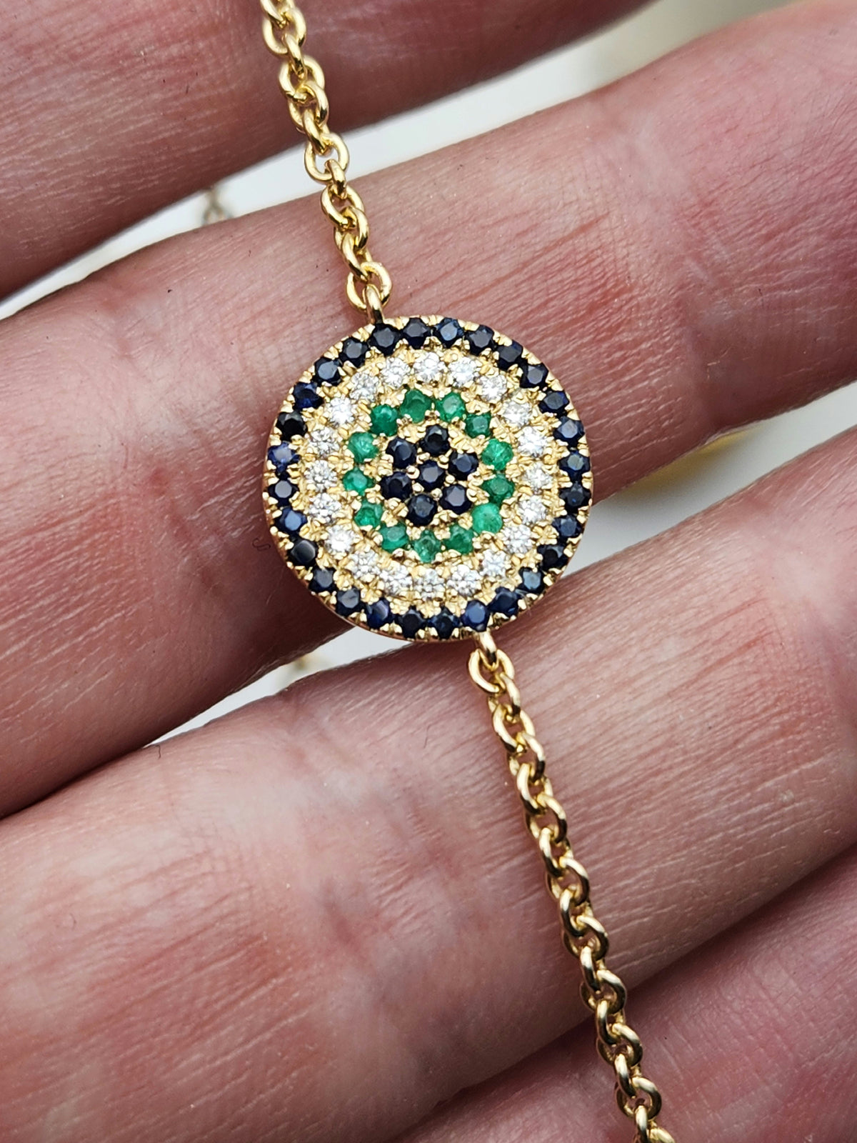 Eye bracelet made from 14k gold set with diamonds ,Sapphires, and Emerald.