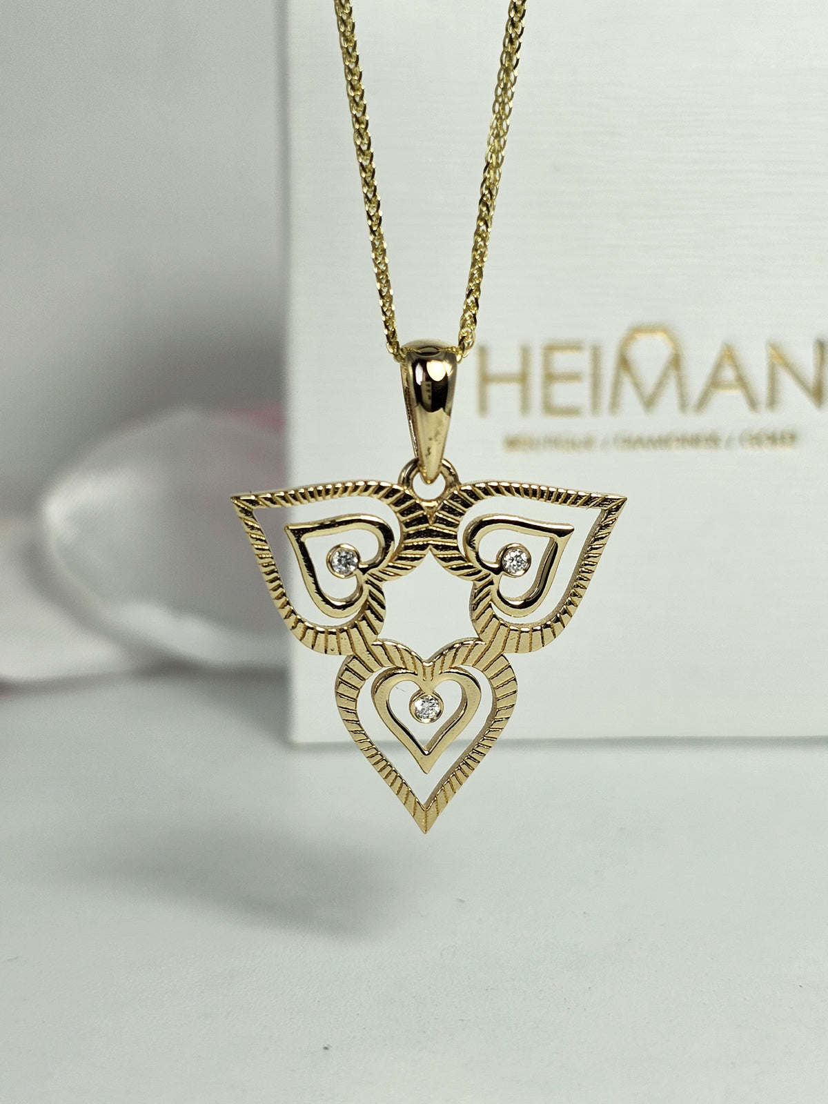 Triple heart pendant set with natural diamonds