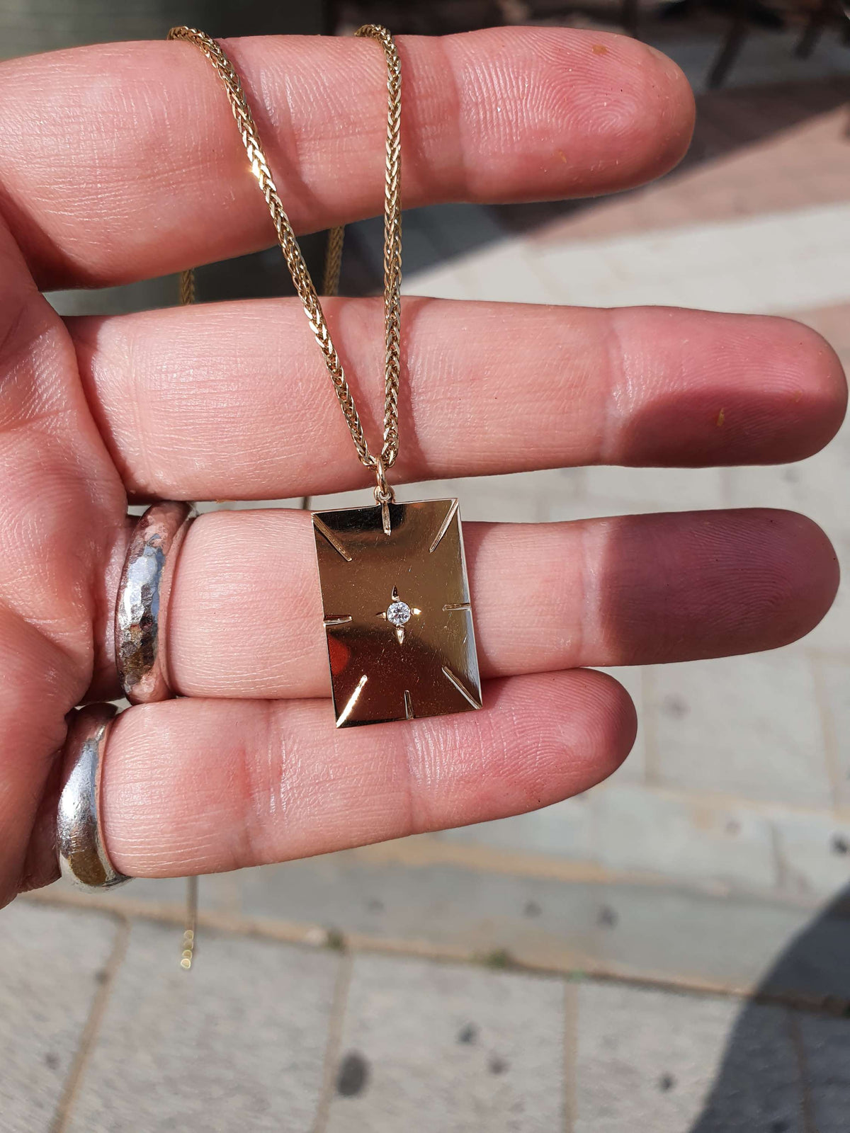 תליון זהב מלבני עם חריטות במרכז יהלום בשיבוץ כוכב