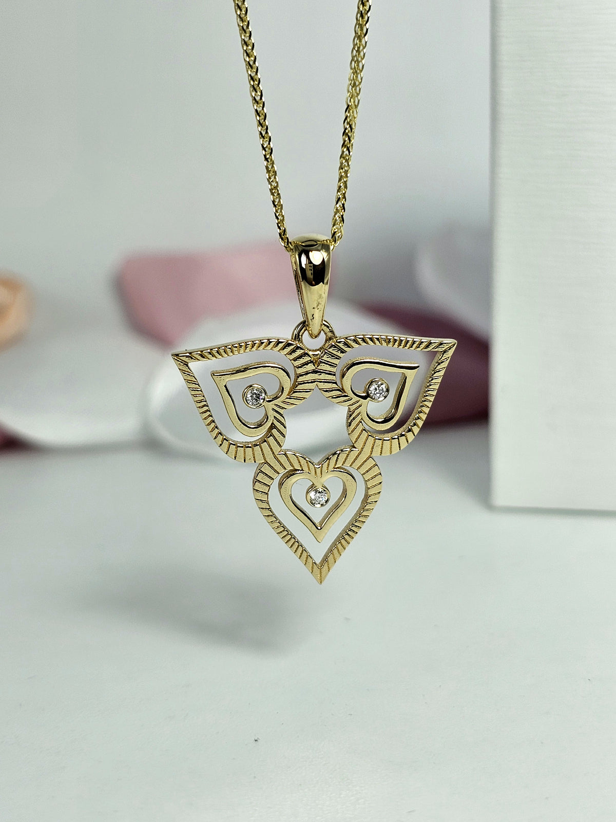 Triple heart pendant set with natural diamonds