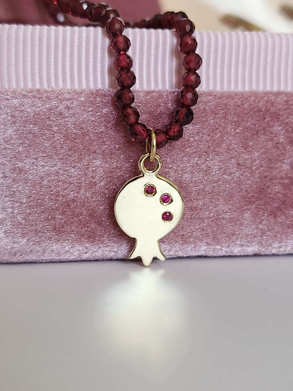 Pomegranate pendant 14k yellow gold set with natural ruby's on garnet string.