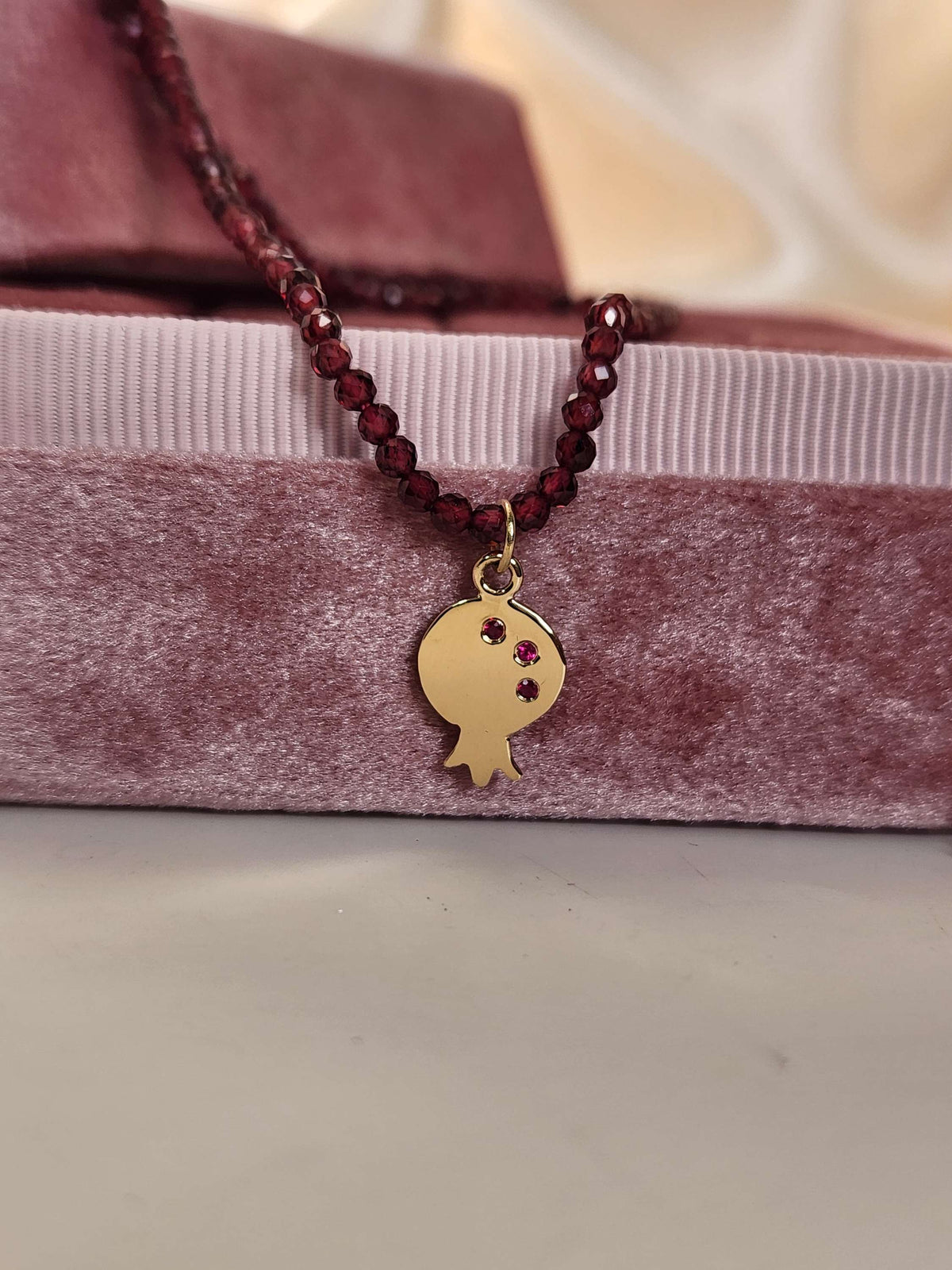 Pomegranate pendant 14k yellow gold set with natural ruby's on garnet string.