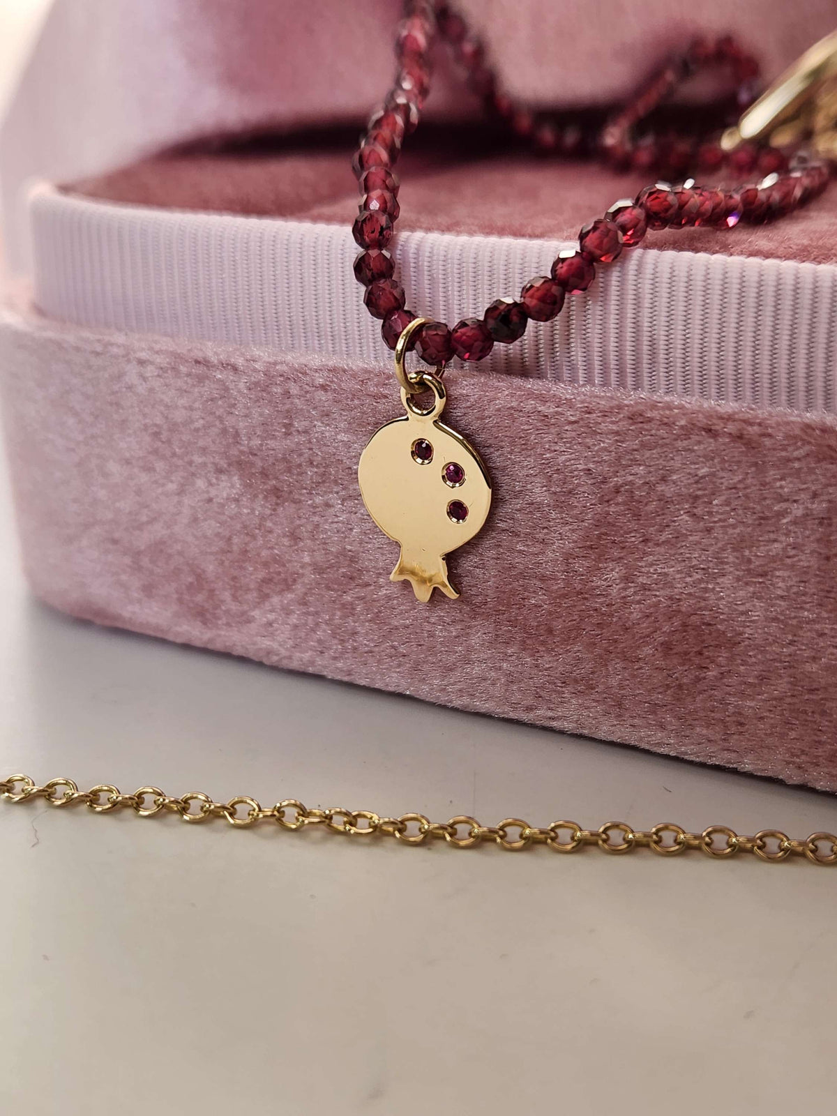 Pomegranate pendant 14k yellow gold set with natural ruby's on garnet string.