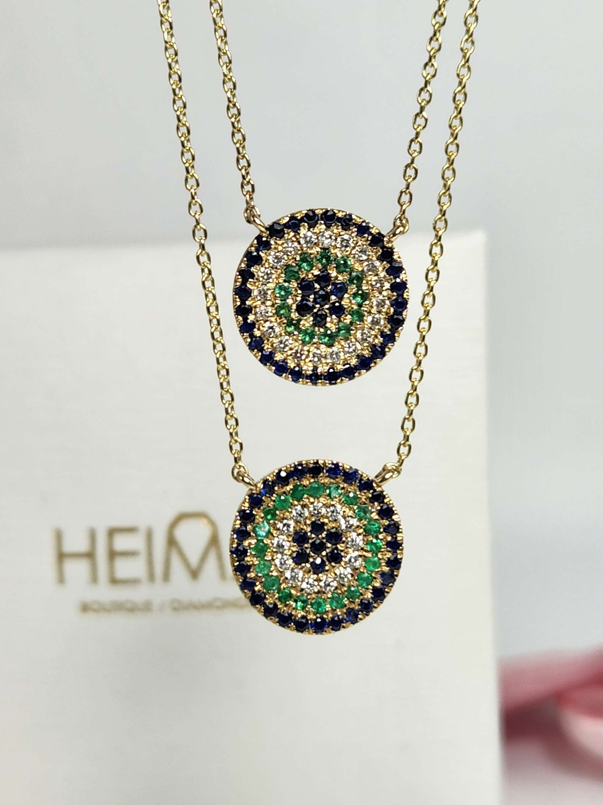 Round eye necklace 14k gold, sapphires, emeralds, and diamonds.