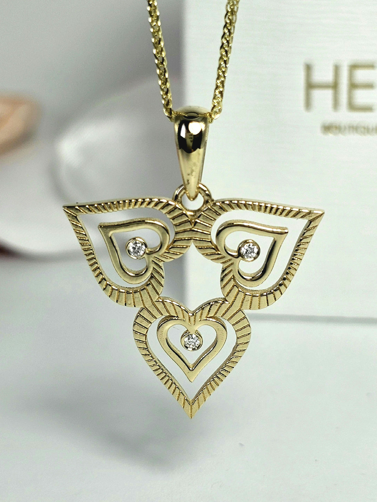 Triple heart pendant set with natural diamonds