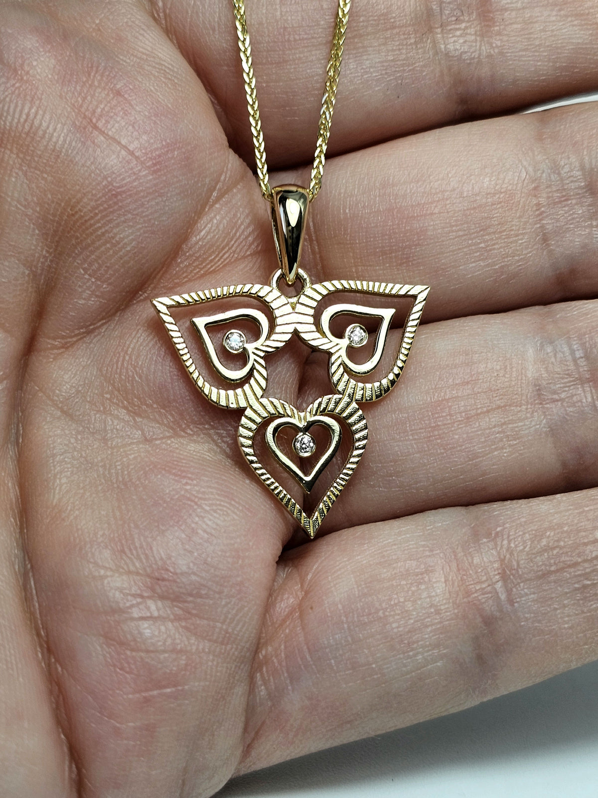 Triple heart pendant set with natural diamonds