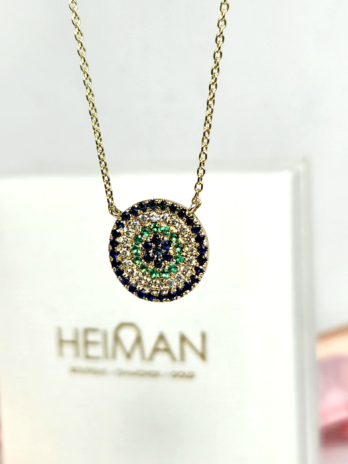 Round eye necklace 14k gold, sapphires, emeralds, and diamonds.