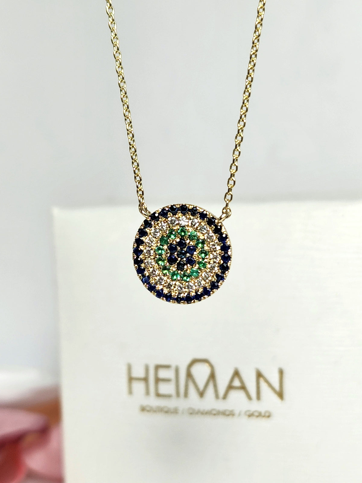 Round eye necklace 14k gold, sapphires, emeralds, and diamonds.