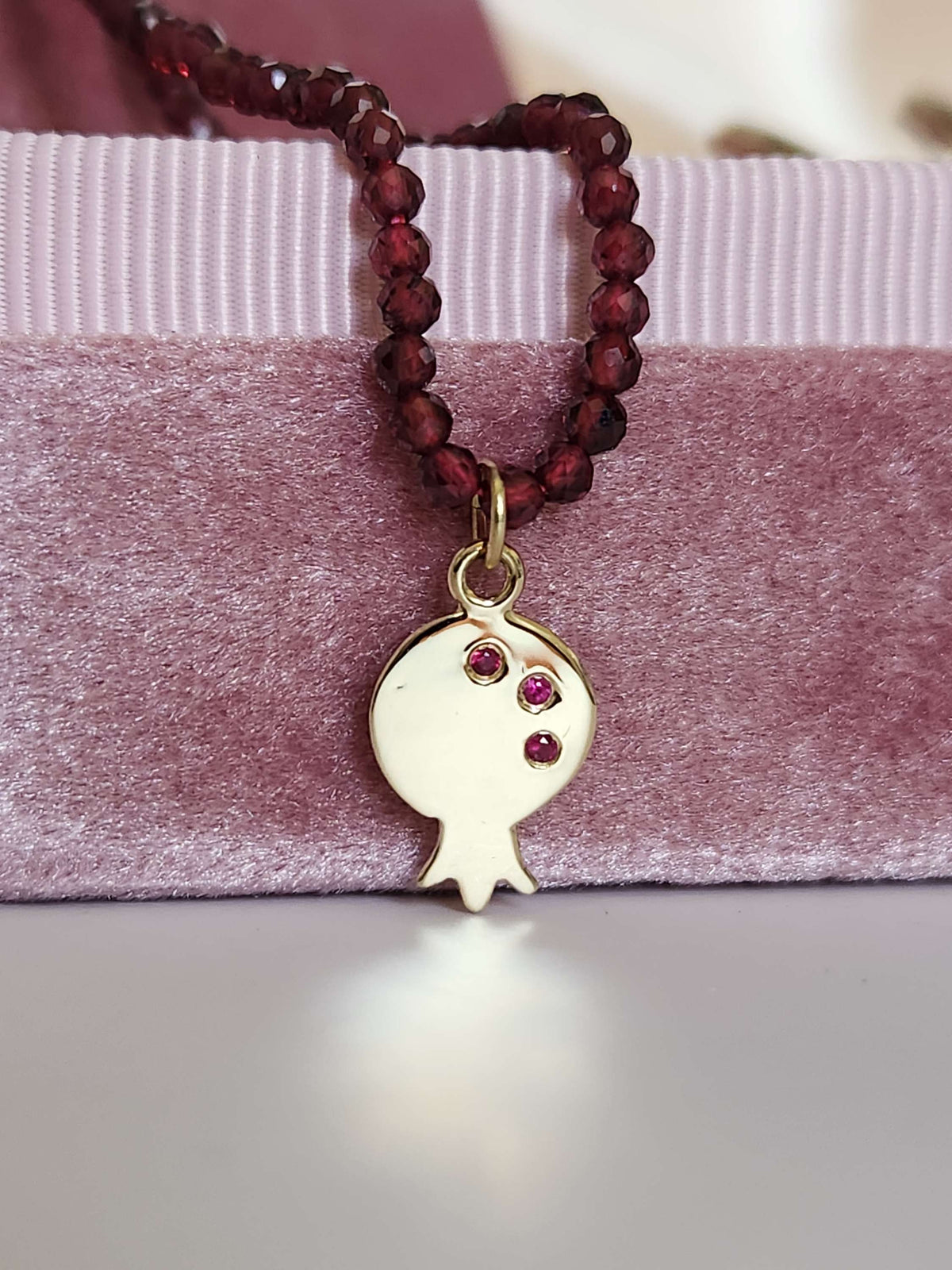 Pomegranate pendant 14k yellow gold set with natural ruby's on garnet string.